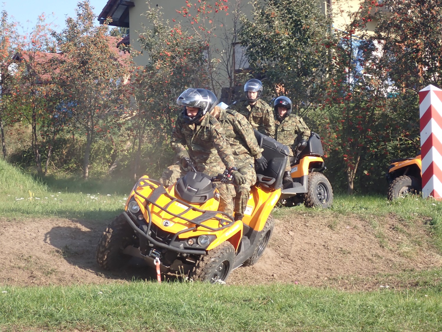 Czterech funkcjonariuszy Straży Granicznej na dwóch pojazdach ATV podczas pokonywania przeszkody.