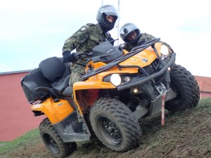  Dwóch funkcjonariusz Straży Granicznej na pojeździe ATV w terenie podczas pokonywania przeszkody.