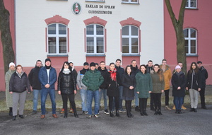 Grupa funkcjonariuszy Straży Granicznej na tle budynku Zakładu ds. Cudzoziemców