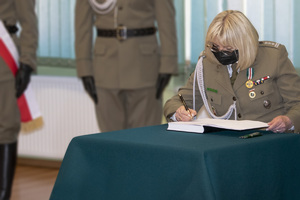 płk SG Małgorzata Sakaluk dokonuje wpisu do księgi pamiątkowej