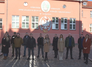 Grupa funkcjonariuszy SG na tle budynku