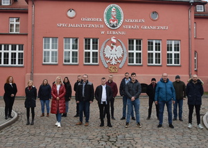 Grupa funkcjonariuszy SG na tle budynku