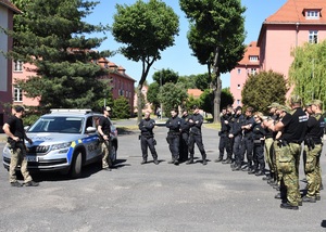 Grupa funkcjonariuszy SG i  Policji Czeskiej w trakcie zajęć na terenie Ośrodka w tle czeski pojazd służbowy