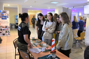 Funkcjonariuszka SG ze studentami Uniwersytetu Wrocławskiego przy stoliku promocyjnym