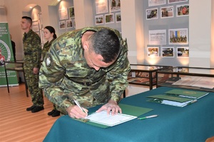 Nowo przyjęty funkcjonariusz SG podpisujący akt mianowania w Sali Tradycji