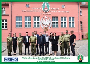 Zdjęcie grupowe przedstawicieli OBWE, Republiki Kirgistanu oraz funkcjonariuszy OSS SG w Lubaniu na tle budynku