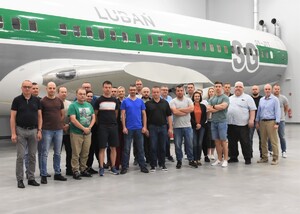 Zdjęcie grupowe uczestników szkolenia w tle kadłub samolotu