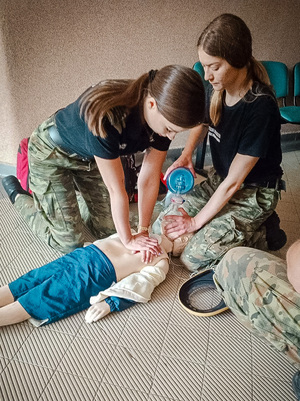 Dwie funkcjonariuszki SG w trakcie zajęć z udzielania pierwszej pomocy dziecku