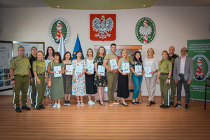 Zdjęcie grupowe przedstawicieli Państwowej Służby Migracyjnej Ukrainy, Komendanta ds. dydaktycznych, wykładowców, tłumacza w Sali Tradycji