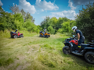 Trzech uczestników szkolenia jadących pojazdami typu ATV podczas zajęć w terenie