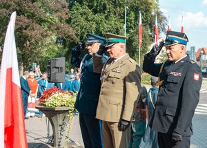 Przedstawiciele służb mundurowych oddają honor przed pomnikiem