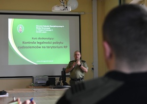 Funkcjonariusz SG prowadzący szkolenie w sali wykładowej Funkcjonariusz SG prowadzący szkolenie w sali wykładowej