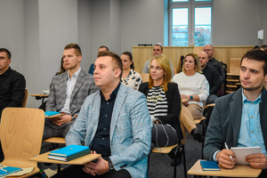 Uczestnicy warsztatów siedzący na krzesłach w sali wykładowej Uczestnicy warsztatów siedzący na krzesłach w sali wykładowej