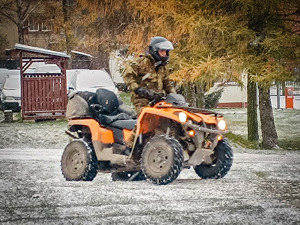 Funkcjonariusz SG siedzący w żółtym pojeździe typu ATV podczas zajęć na terenie Ośrodka Funkcjonariusz SG siedzący w żółtym pojeździe typu ATV podczas zajęć na terenie Ośrodka