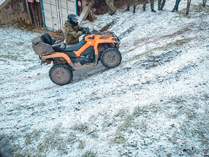 Funkcjonariusz SG siedzący w żółtym pojeździe typu ATV podczas zajęć na terenie Ośrodka Funkcjonariusz SG siedzący w żółtym pojeździe typu ATV podczas zajęć na terenie Ośrodka