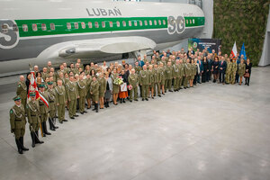 Zdjęcie grupowe uczestników uroczystości na tle kadłuba Boeinga 737