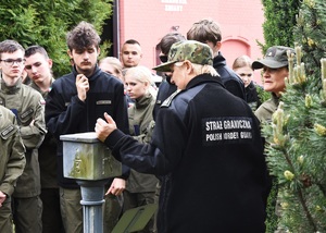 Uczniowie z Gorzowa Wielkopolskiego z wizytą w OSS SG w Lubaniu Funkcjonariuszka SG oprowadzająca uczniów po lapidarium znaków granicznych