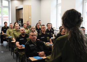 Kurs doskonalący pt. „Postępowanie w sprawie zobowiązania cudzoziemca do powrotu” Grupa funkcjonariuszy SG, siedzi na krzesłach w sali wykładowej podczas szkolenia