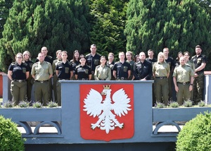 Przeprowadzanie przez funkcjonariuszy Straży Granicznej kontroli legalności wykonywania pracy przez cudzoziemców, prowadzenia działalności gospodarczej przez cudzoziemców, powierzania wykonywania pracy cudzoziemcom Zdjęcie grupowe funkcjonariuszy SG na trybunie ośrodka