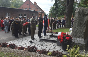 Przedstawiciele Straży Granicznej, Straży Miejskiej oraz Policji salutują przy Symbolicznej Mogile ofiar łagrów, zsyłek i innych miejsc kaźni Przedstawiciele Straży Granicznej, Straży Miejskiej oraz Policji salutują przy Symbolicznej Mogile ofiar łagrów, zsyłek i innych miejsc kaźni