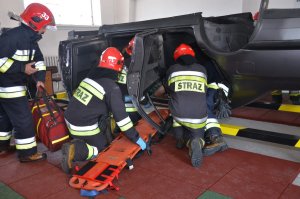  Funkcjonariusze Straży Pożarnej podczas szkolenia na symulatorze dachowania pojazdu